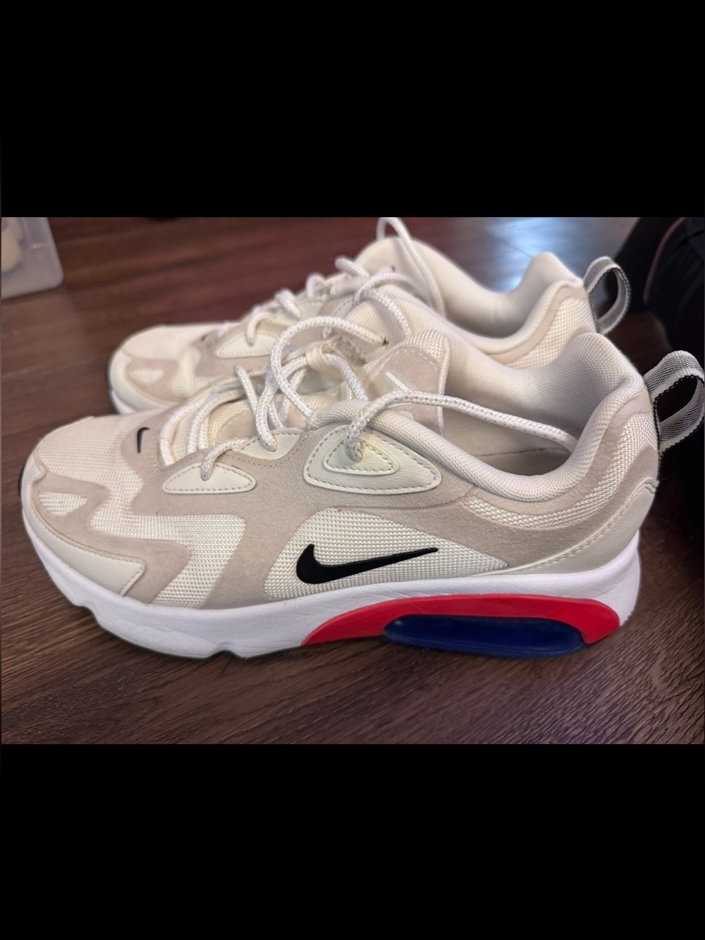Nike White and Beige Sneakers with Black Swoosh and Red/Blue Sole Accents